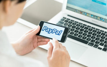 Person holding a brand new Apple iPhone 5S with PayPal logo on a screen (1) Person holding a brand new Apple iPhone 5S with PayPal logo on a screen (1)