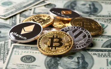 İstanbul, Turkey - January 24, 2018: Close up shot of bitcoin, lite coin and ethereum memorial coins on a US paper dollars. Bitcoin, Lite coin and Ethereum are crypto currencies and a worldwide payment systems.